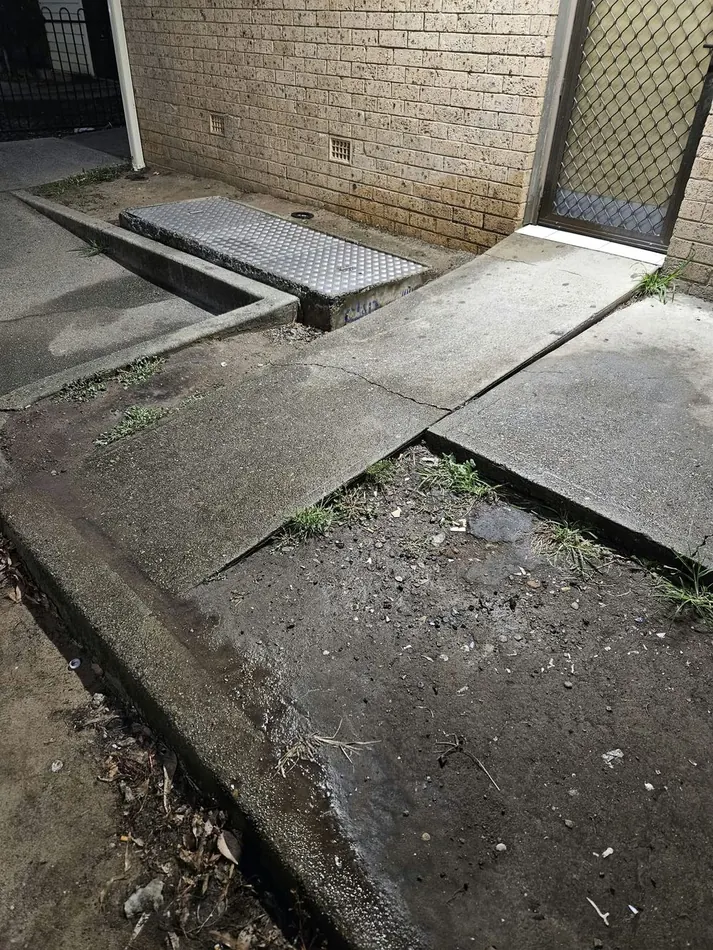 Cracked concrete path before repair