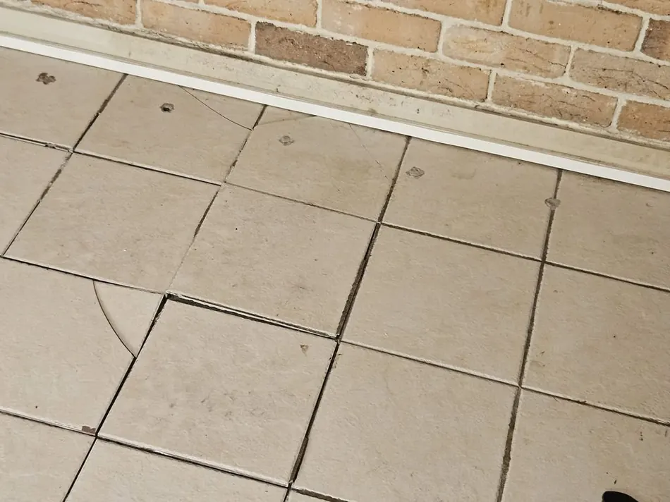 Damaged, ungrouted tile before repair